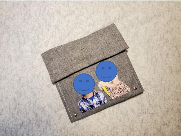 Grey cloth pouch, with a resistor attached to the top flap, and photos of the maker's children on the front