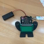 A small, wearable device shaped like a bear made of micro bit components.