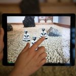 A tablet screen displaying a zen garden with miniature statues of Buddha.